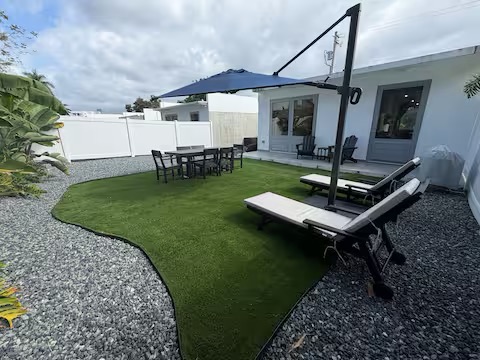 Backyard outdoor space with lounge chairs and umbrella